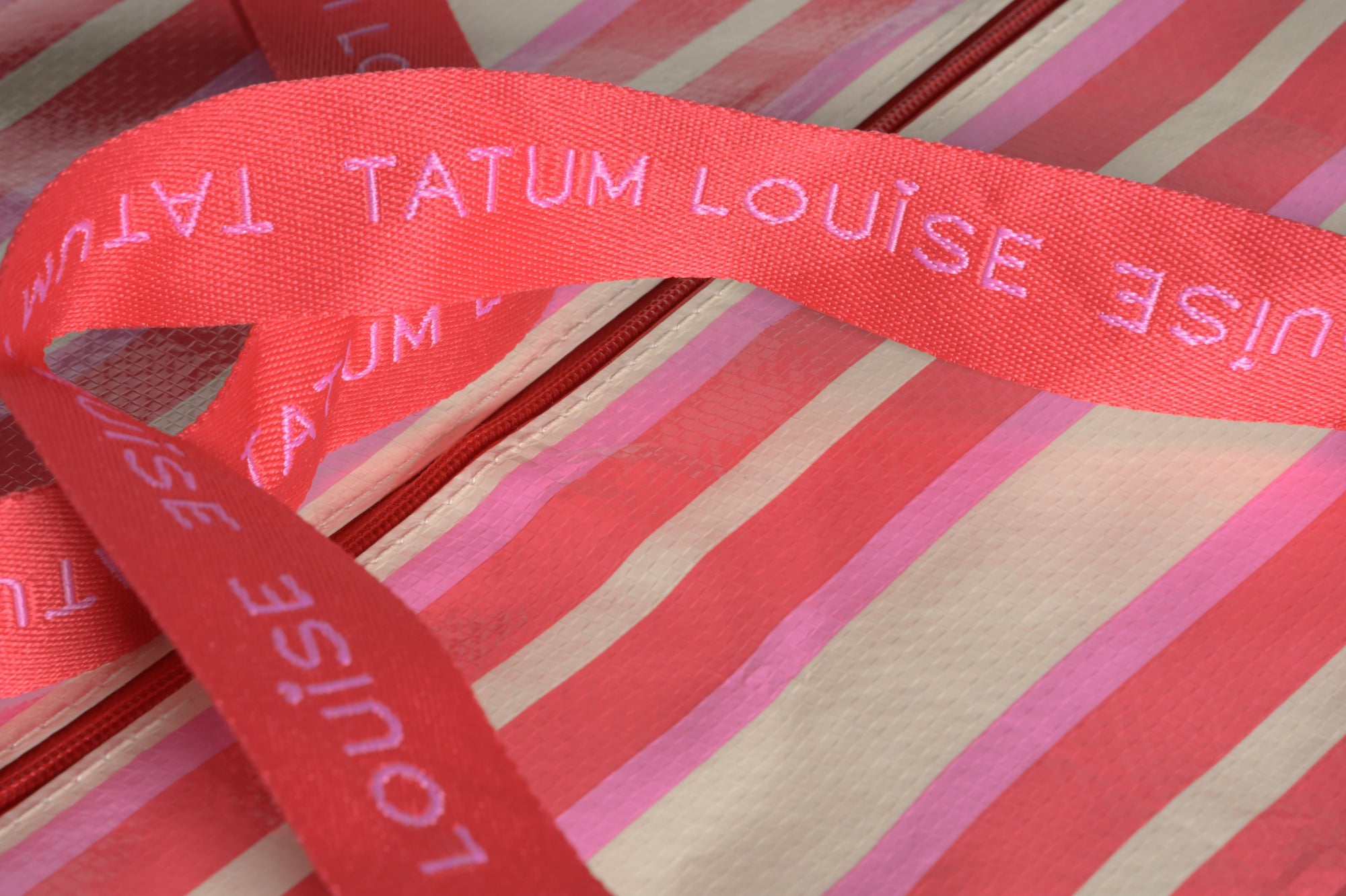 Durable red and pink handles on the Peony Pink TATUM LOUISE bag. 