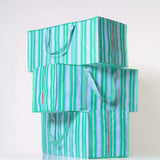 Stack of green and white striped eco-friendly moving bags on a white background