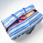 Blue and white striped moving bag with a red zipper on a white background