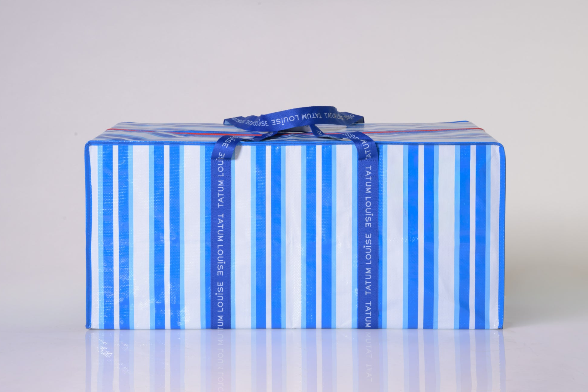 heavy-duty moving bag with blue and white striped design and dark blue durable handles.