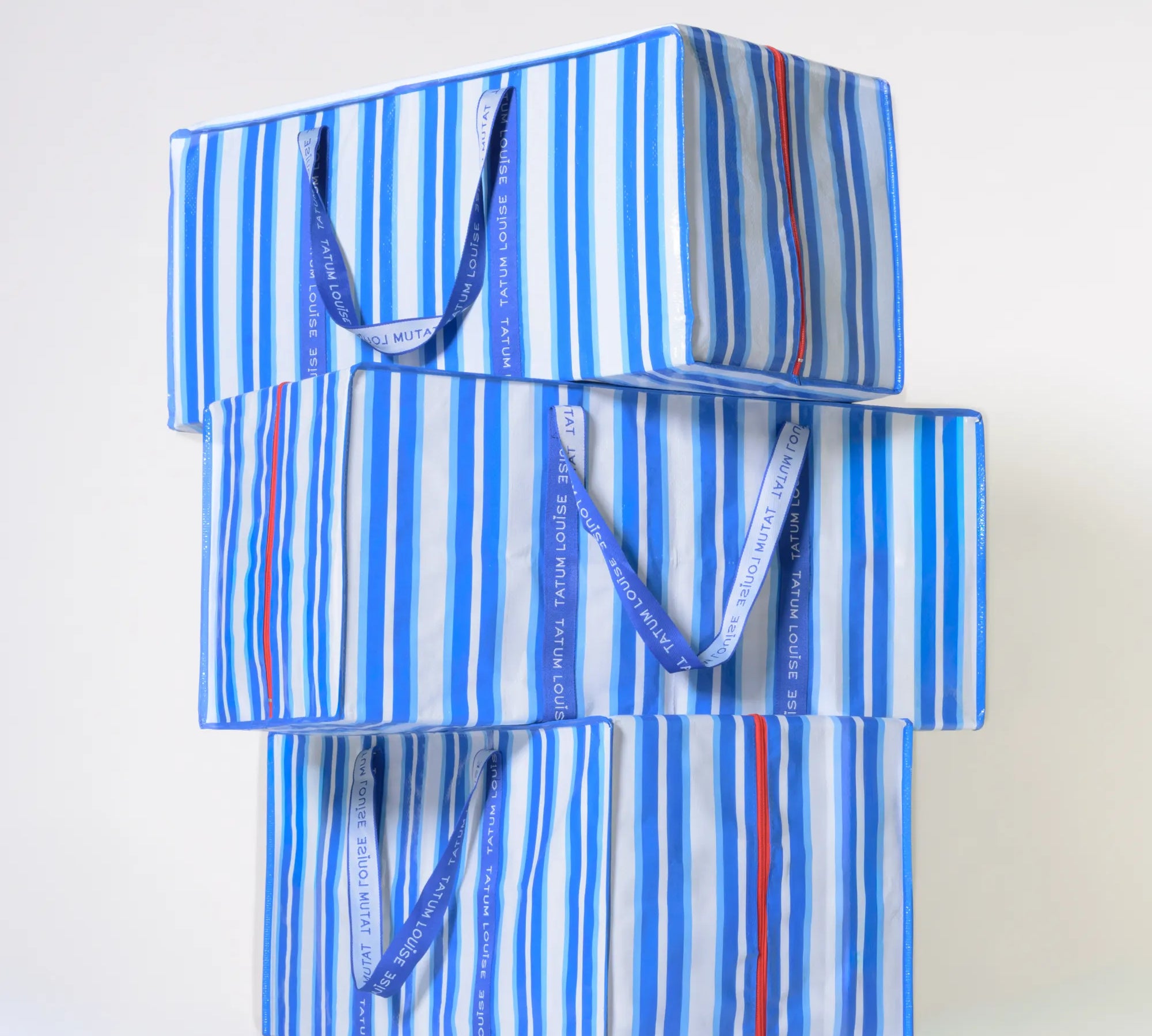 Blue striped reusable moving bag with handles on a white background