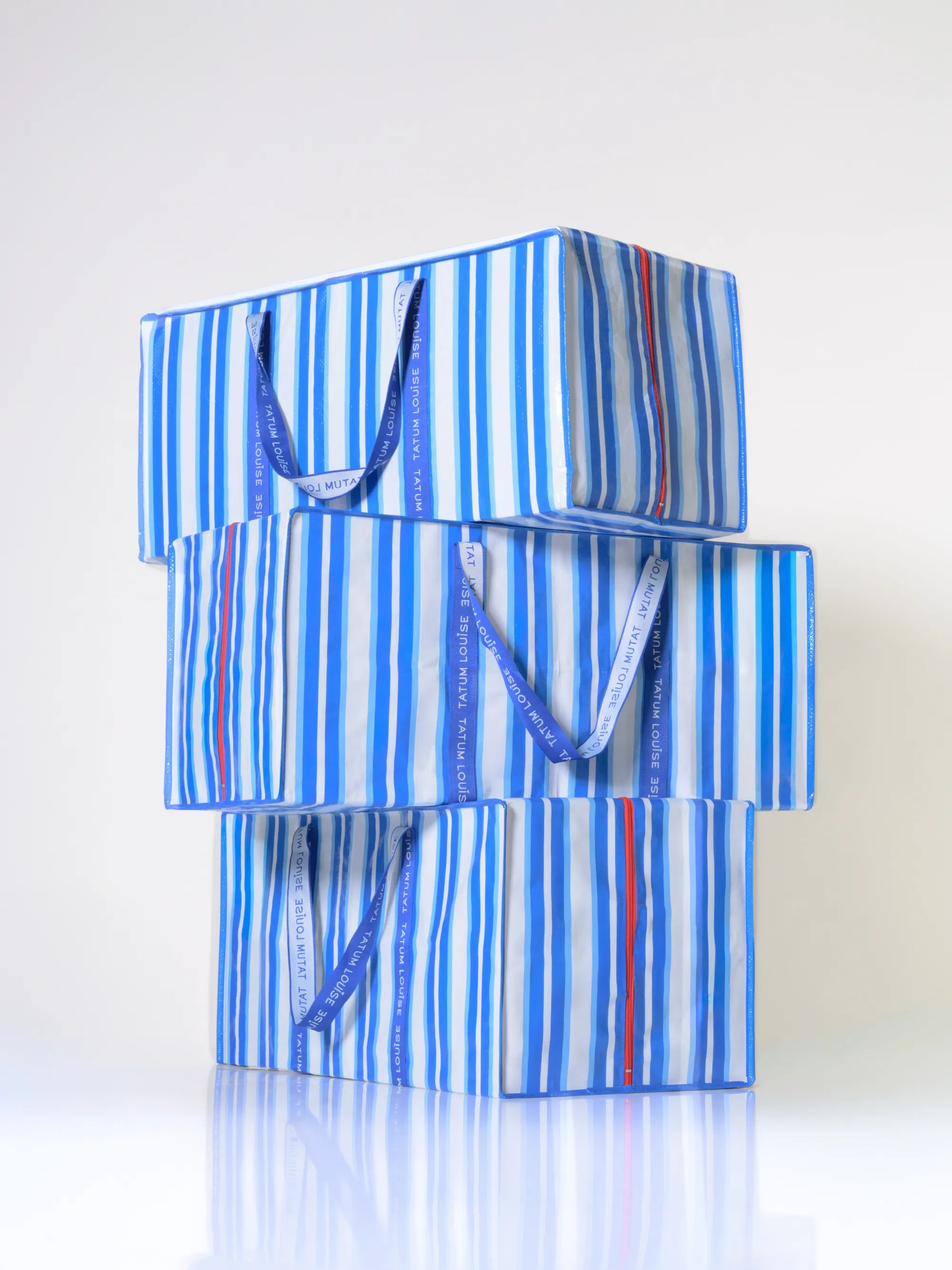 Blue striped reusable moving bag with handles on a white background