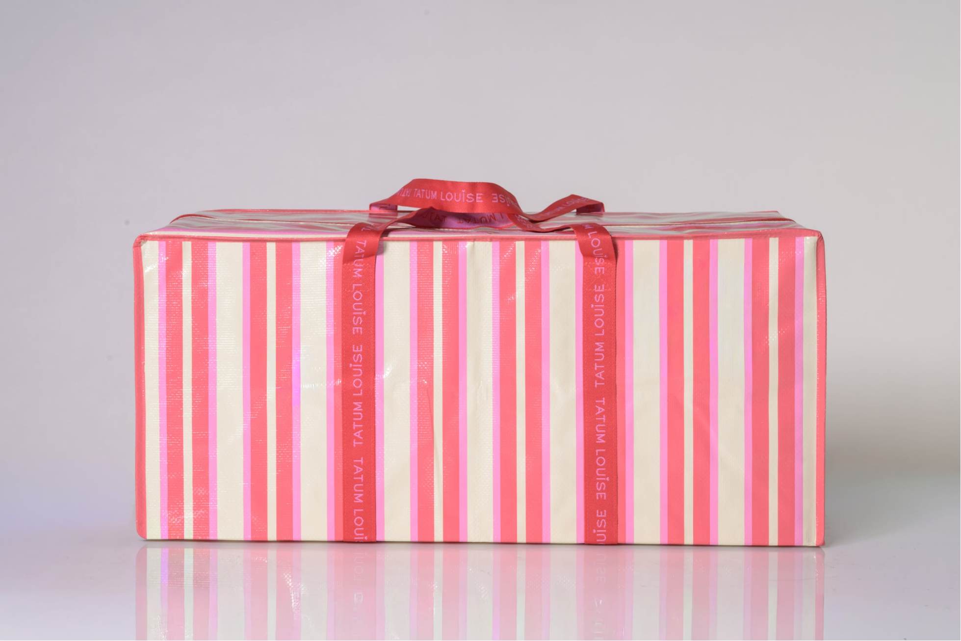 Reusable moving bag for college with red and white striped design and heavy duty red handles.