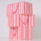 Stack of pink and white striped reusable moving bags for college on a white background