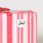 Striped pink and red dorm moving bag with water-resistant label holder.